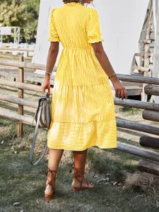 Back view of a yellow striped summer dress with tiered skirt and elastic waist.