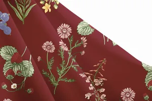 Detailed macro view showing the elegant floral print texture on a burgundy vacation dress