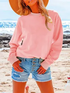 Casual loose pink long sleeve crewneck sweatshirt for women shown in a beach setting