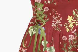 Detailed close-up of a red floral vacation dress with green satin lace-up ribbon