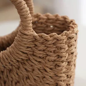 Detailed view of a handwoven straw beach bag featuring a sturdy braided handle detail