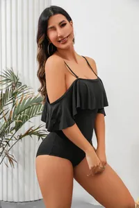 Detail of black one-piece swimsuit featuring elegant ruffles and slim straps.