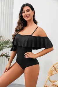 Elegant black ruffled off-shoulder swimsuit for women in a studio setting