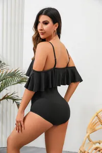 Side view of black one-piece swimsuit with elegant ruffles and ribbed fabric texture.