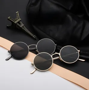 Detail view of round metal sunglasses with retro punk aesthetic in gold and silver