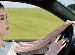 Woman wearing pink ice silk sun protection arm sleeves while driving a car outdoors
