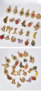 Collection of various gold stainless steel enamel DIY pendants on textured background