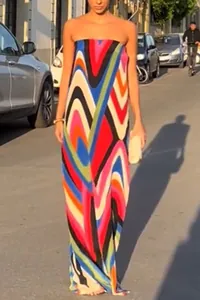 Detailed shot of vibrant wave print strapless maxi dress in a colorful lifestyle street setting.