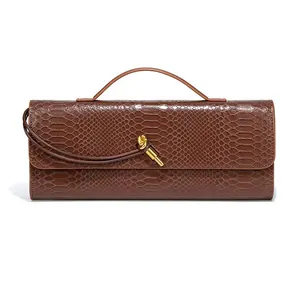 Detailed view of a brown snakeskin pattern baguette bag with a gold metal knot.