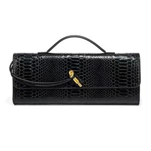 Close-up of black snakeskin texture and iconic golden knot clasp on baguette bag