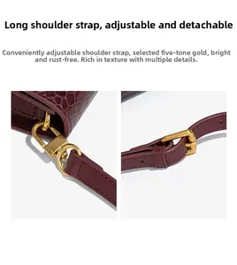 Detail of adjustable and detachable strap hardware on burgundy snakeskin baguette bag