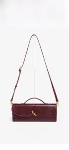 Detailed view of wine red snake-patterned baguette bag with adjustable strap measurements.