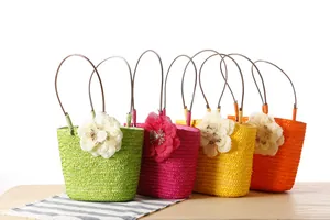 Close-up of four colorful woven straw handbags with decorative flowers for summer.