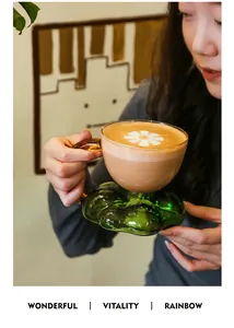 Elegant cloud-shaped green glass saucer with amber coffee cup and latte art.