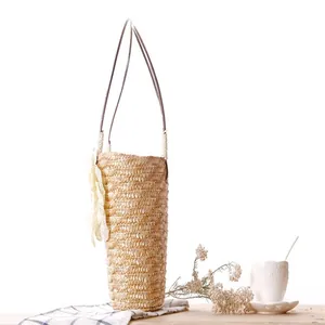 Detailed side view of a natural woven straw beach bag with elegant white lace flower.