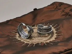 Close-up of S925 sterling silver nomad eagle feather and coin engraved rings.