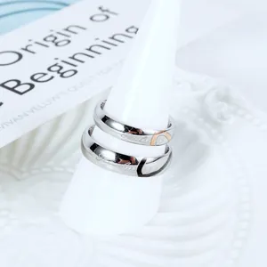 Simple stainless steel couple rings with interlocking heart design on white stand