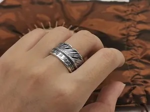 Detailed view of vintage S925 sterling silver feather ring with United engraving on hand