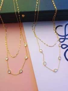 Double-layered gold titanium steel necklace with elegant teardrop shell pendants detail.