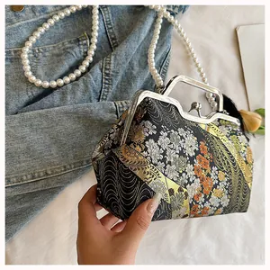Detailed view of vintage Chinese embroidery handbag with pearl chain and metal clasp