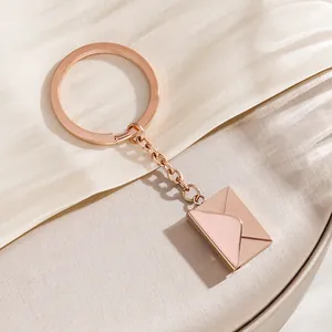 Elegant rose gold envelope keychain with a delicate chain and polished charm pendant