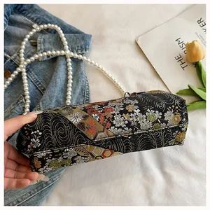 Close-up shot showing the side profile and exquisite pearl strap of the floral handbag
