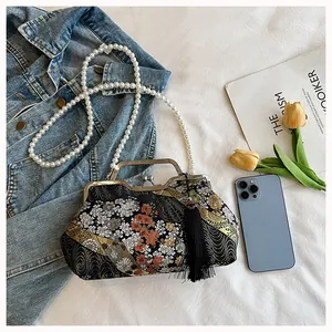 Detail of Chinese-style embroidered handbag with pearl chain strap and silk tassel