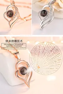 Close-up of heart projection necklace showing 100 languages of I Love You in rose gold