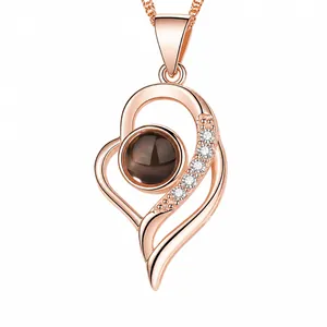 Close-up of heart projection necklace showing 100 languages of I Love You in rose gold