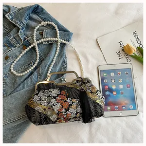 Close-up of a Chinese style floral embroidery bag featuring a pearl strap and tassel