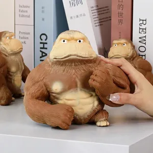 Gros plan d'un jouet anti-stress gorille brun musclé pressé par une main d'une femme