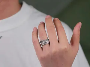 Detailed view of a S925 sterling silver feather open ring on a male finger.
