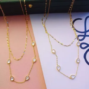 Elegante collana dorata a doppio strato con pendenti a goccia in madreperla in titanio.