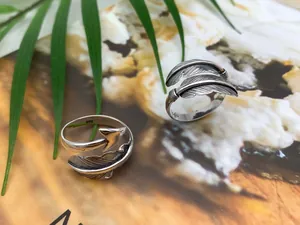 Macro detail of two S925 sterling silver feather and arrow adjustable open rings