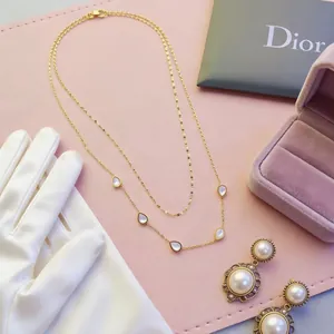 Elegante collana a doppio strato in acciaio dorato con intarsi in madreperla a goccia