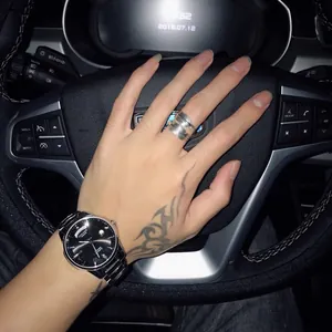 Detailed view of an S925 sterling silver open feather ring on a tattooed hand