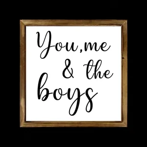 Detailed view of square wooden frame sign with 'You, me & the boys' black cursive script