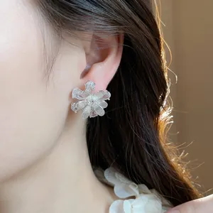 Elegante Blumenstecker aus S925 Silber mit funkelnden Zirkonia am Modell getragen