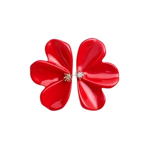 Elegant red resin flower stud earrings with shimmering center detail on white backdrop.