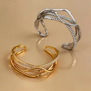 Close-up of elegant 18k gold and silver plated multi-layer rhinestone cuff bracelets.