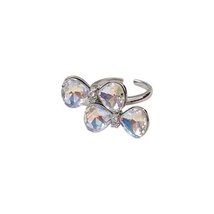 Eleganter silberfarbener offener Ring mit schillernden facettierten Schleifensteinen