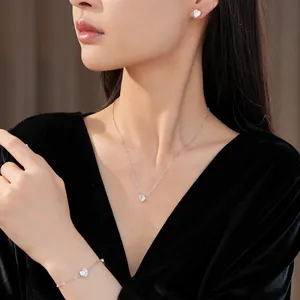 Elegant Asian model wearing minimalist heart-shaped zircon necklace and jewelry set