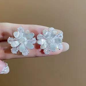 Detailaufnahme funkelnder Zirkon-Blumenohrstecker mit silbernen Blütenblättern