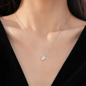 Close-up detail of minimalist heart pendant necklace with zircon on a model