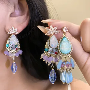 Detail view of vintage palace style teardrop tassel earrings with zircons and crystals
