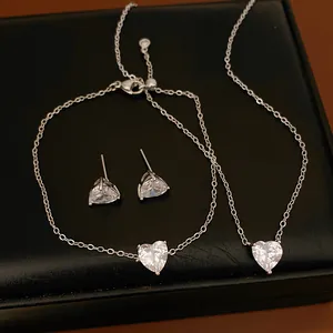 Elegant close-up of a minimalist silver-tone jewelry set with heart-shaped sparkling zircons