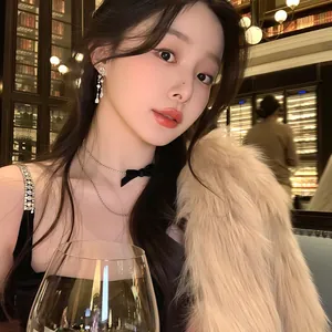 Close-up of model wearing zircon water drop tassel earrings in a luxury setting.