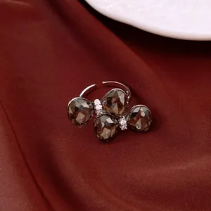 Nahaufnahme eines eleganten offenen Rings mit dunkelgrauen Kristallen und Strasssteinen