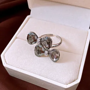 Nahaufnahme eines glitzernden Schleifen-Blumenrings mit grauen Steinen in einer Box