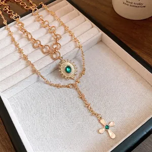 Vintage gold-plated layered necklace with cross and sunburst green stone pendants